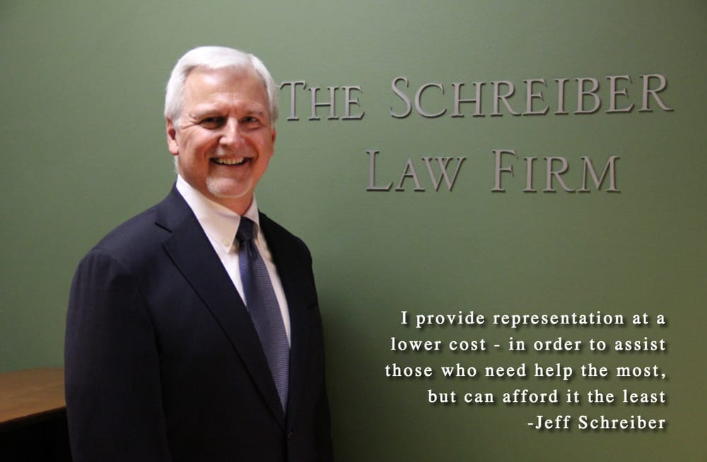 Jeff Schreiber standing beside The Schreiber Law Firm office sign